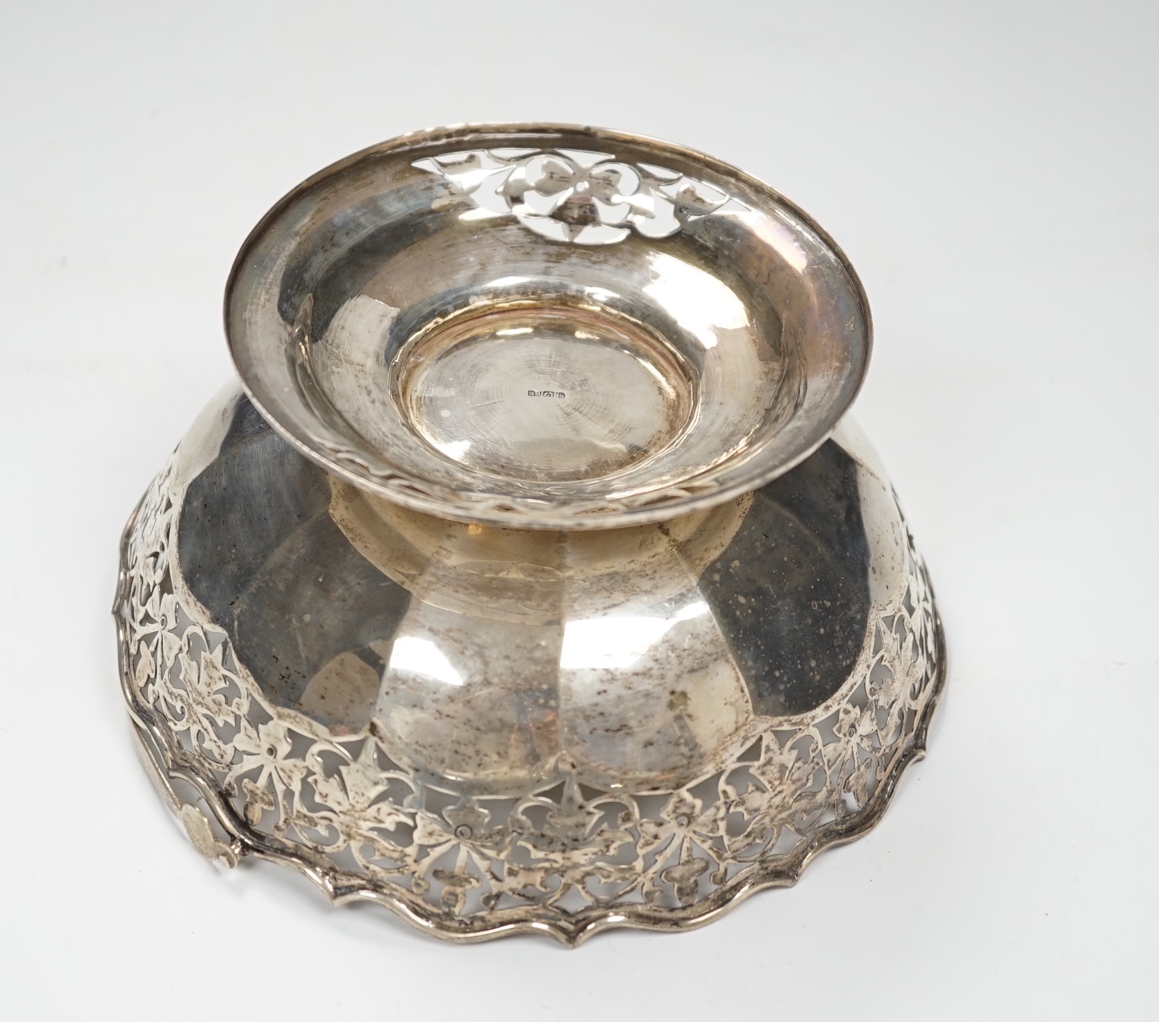 An Edwardian embossed silver sugar caster, Birmingham, 1904, 17.6cm and white metal cake basket stamped 'silver'.